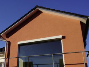 Fassade eines Hausanbaus mit orangenem Anstrich